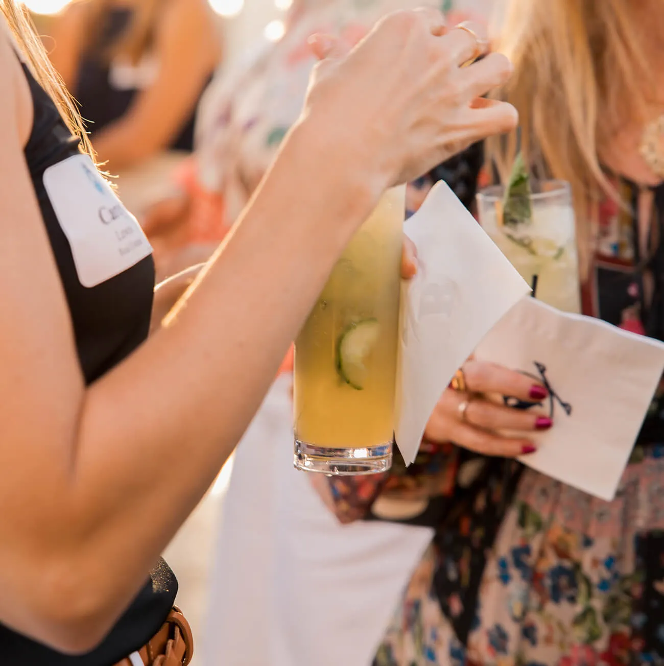 Guest holding a refreshing cucumber cocktail at a social gathering