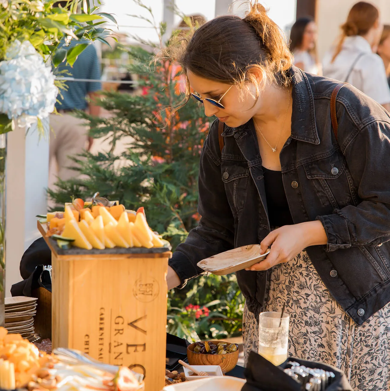 Guest enjoying a cheese and charcuterie buffet at an outdoor social event