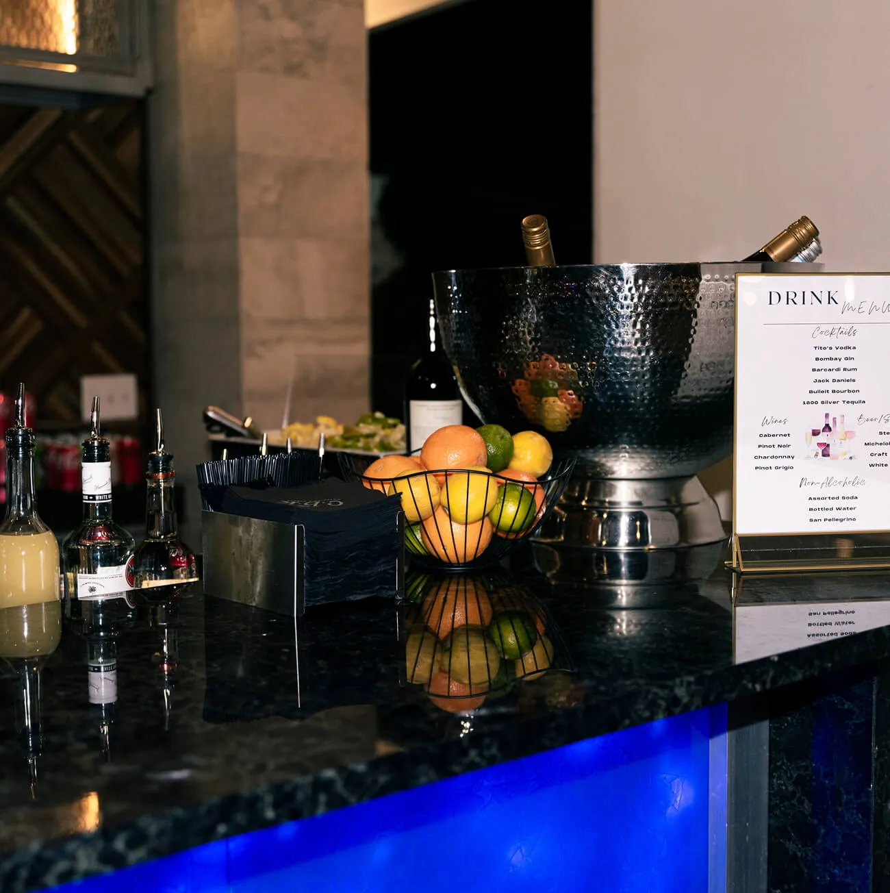 Upscale bar setup with citrus, ice bucket, and printed drink menu