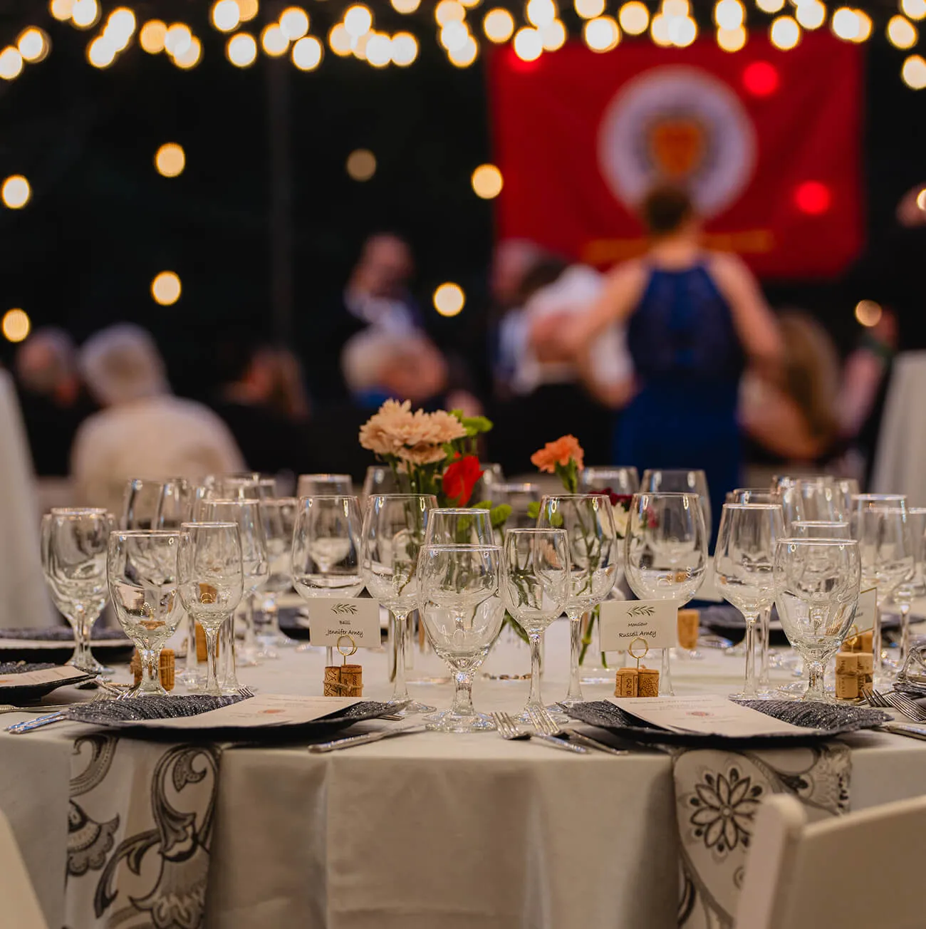 Outdoor evening wedding reception table with string lights and place settings