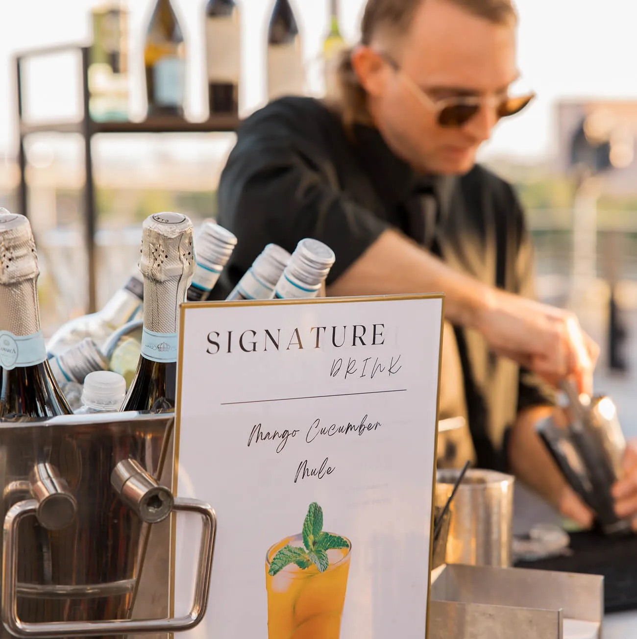 Signature Mango Cucumber Mule bar with chilled bottles and bartender in action
