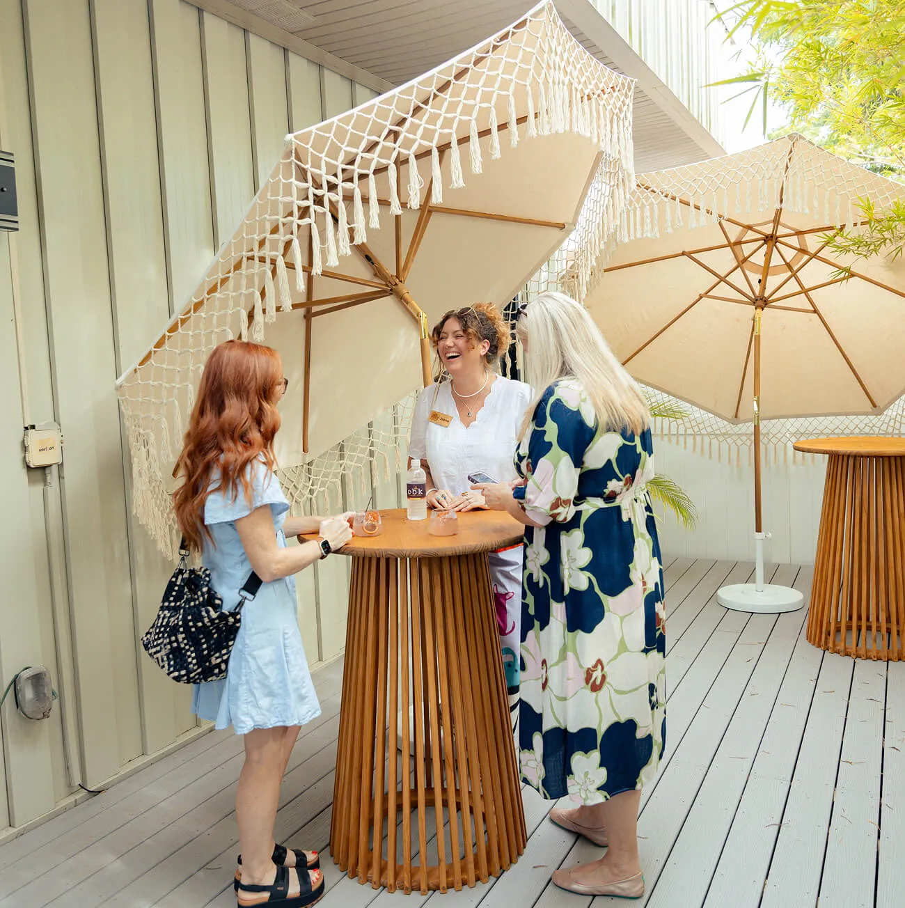 Guests socializing around a patio bistro table at an outdoor event