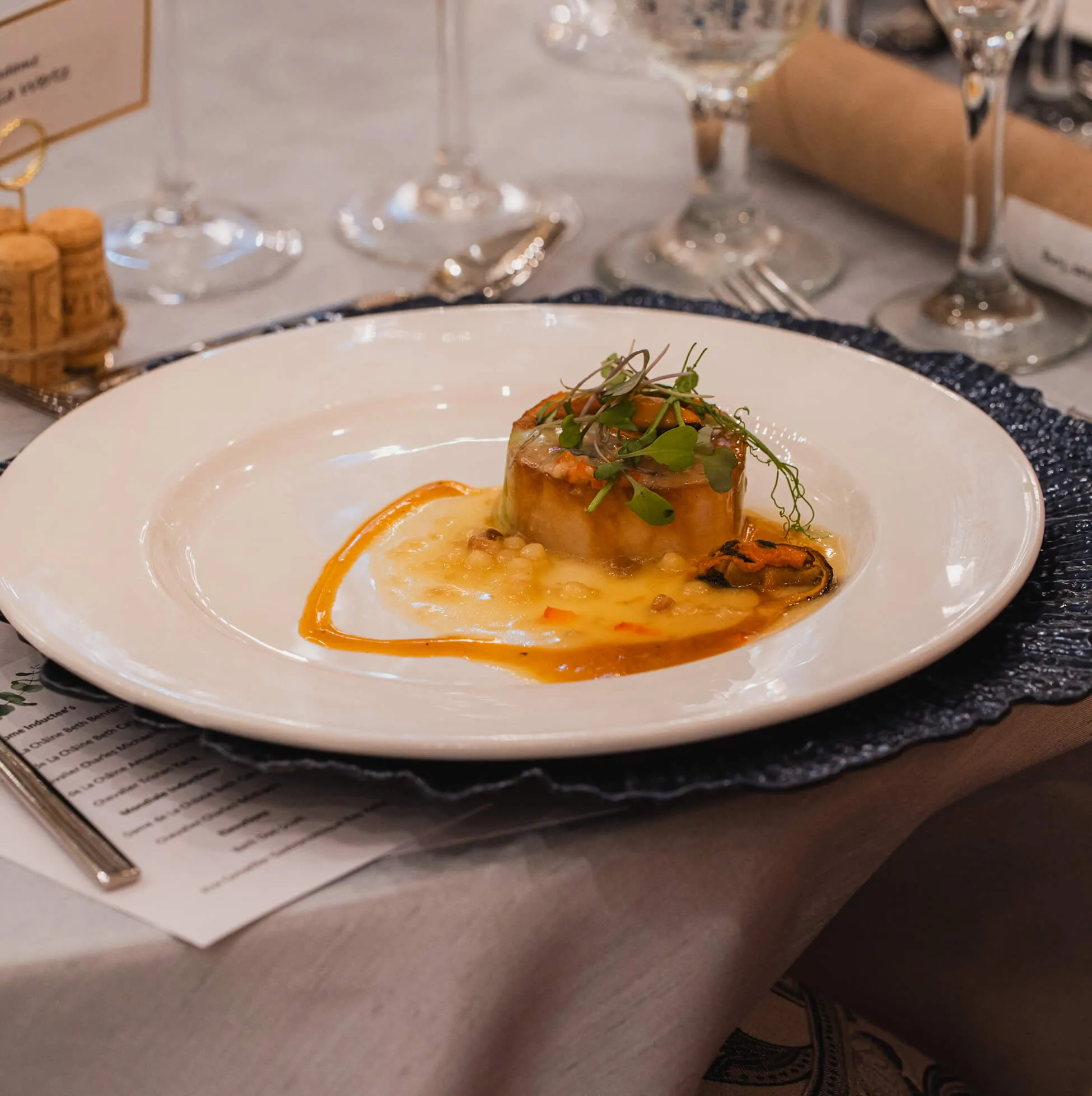 Gourmet plated entree with seasonal garnish at a formal dinner