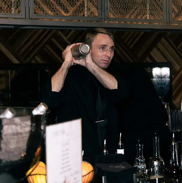 Bartender shaking a cocktail behind a modern bar