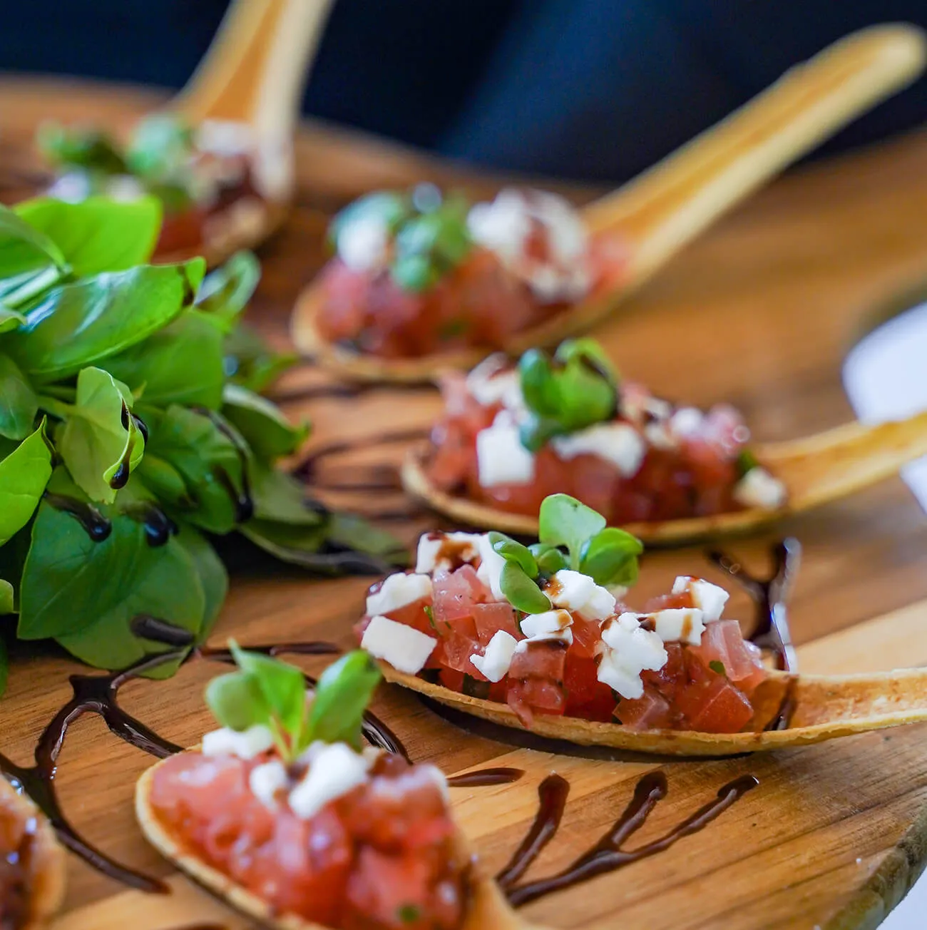 Bruschetta appetizers served on edible spoons with balsamic drizzle
